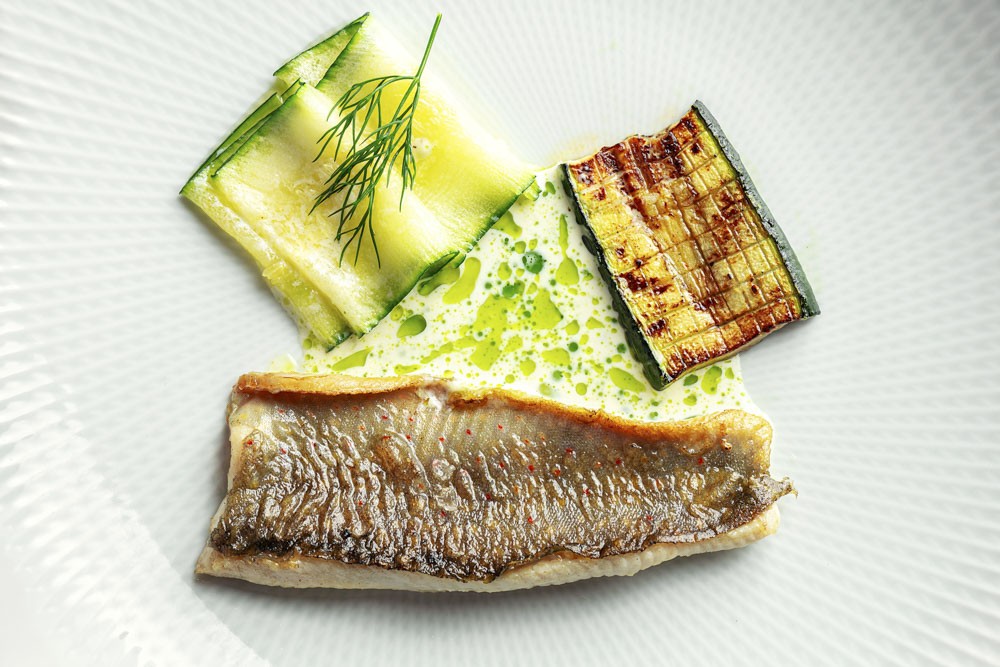 Trout fillet with roasted zucchini and cream sauce with dill oil